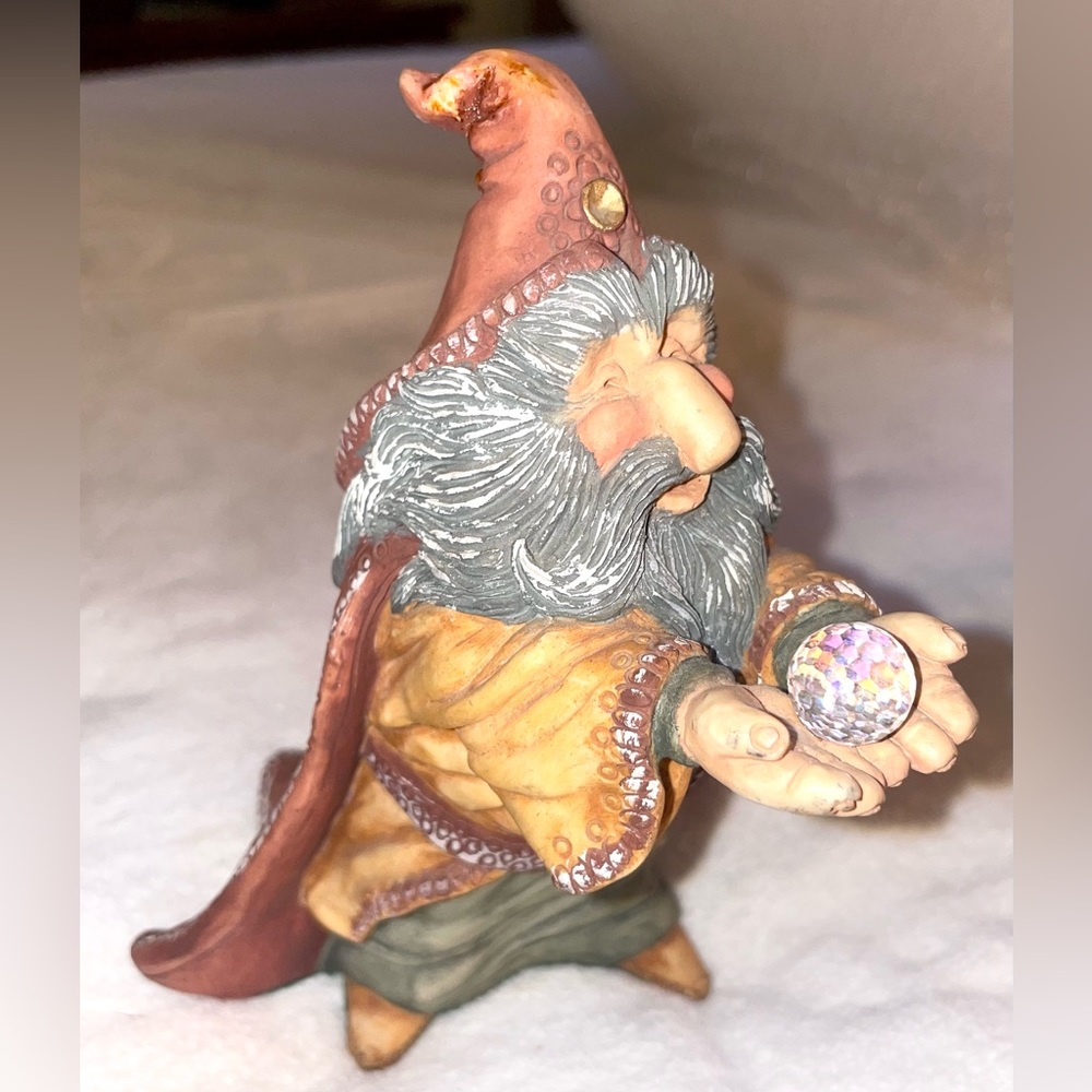 Krystonia man with hood and beard holding a crystal ball